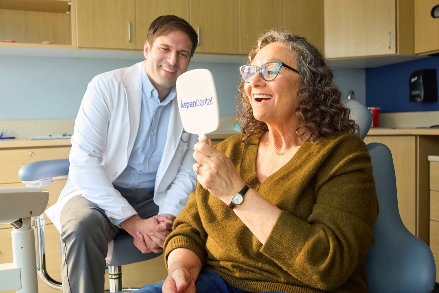 Aspen Dental patient smiling in the exam chair with her dentist