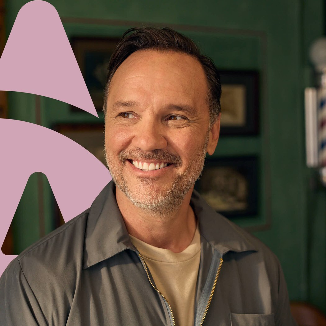 A smiling Aspen Dental patient in a barber shop